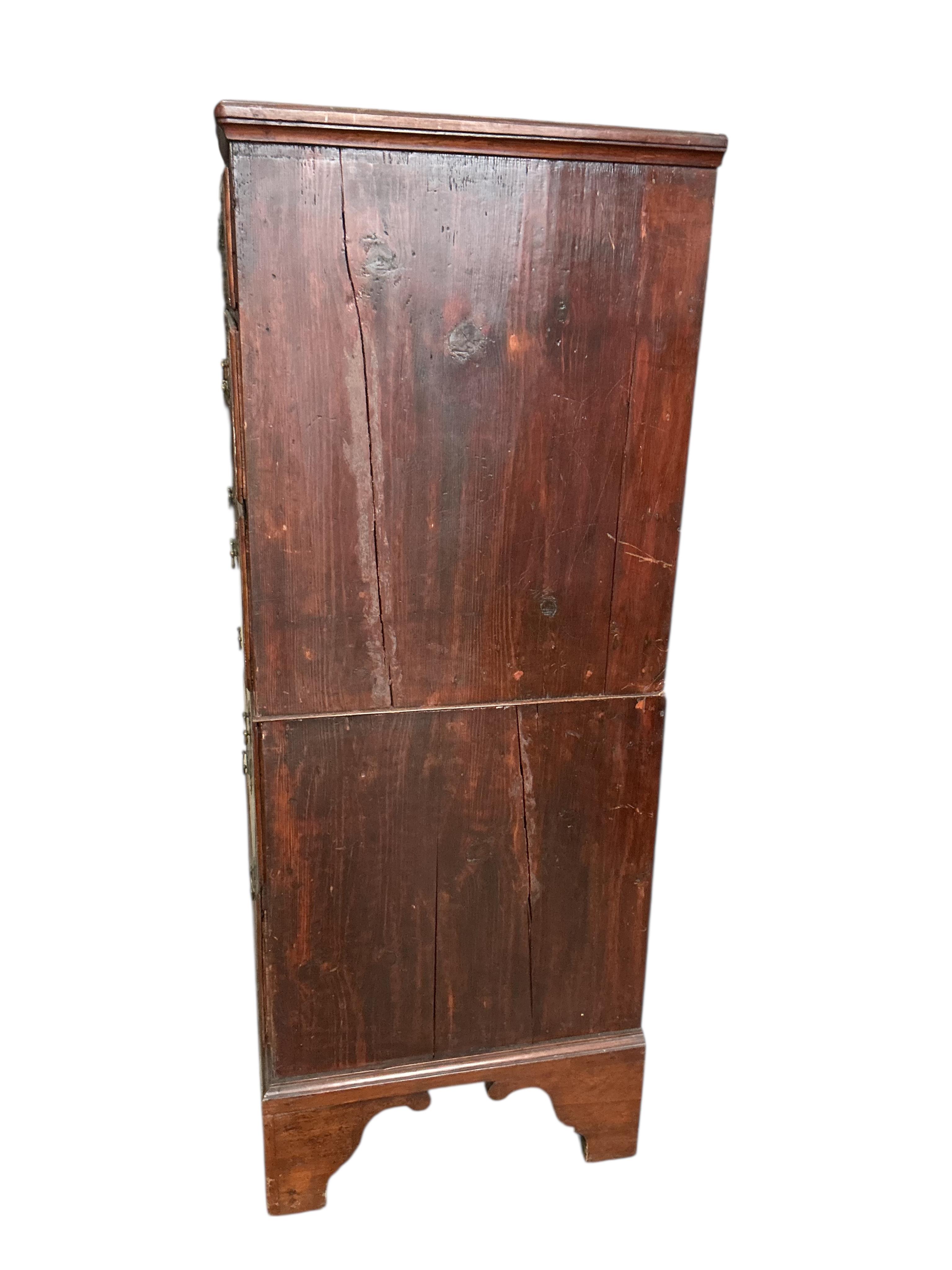 An early 18th century feather banded walnut and pine two section chest of drawers, on later bracket feet and with losses, width 96cm, depth 52cm, height 135cm